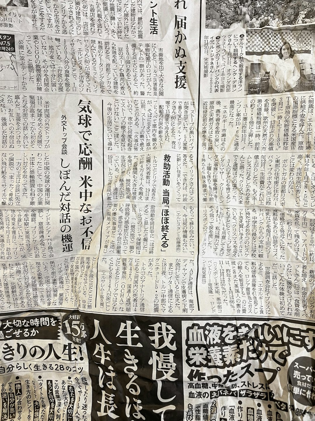 Eine aufgeschlagene japanische Zeitung mit Textspalten und Bildern.